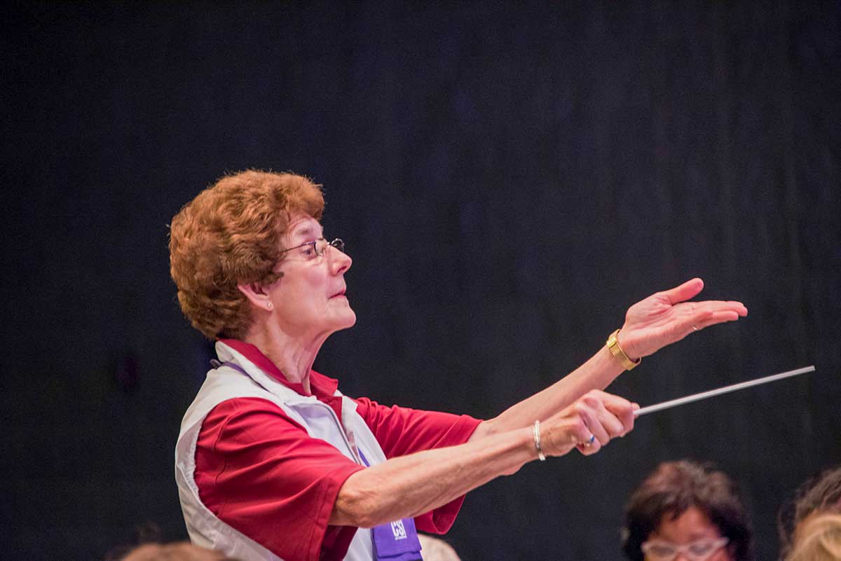 Paula Crider helping conduct a music reading session.